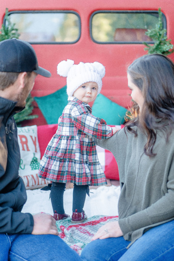 Exploring toddler in the back of truck bed for holiday red truck minis in Oregon